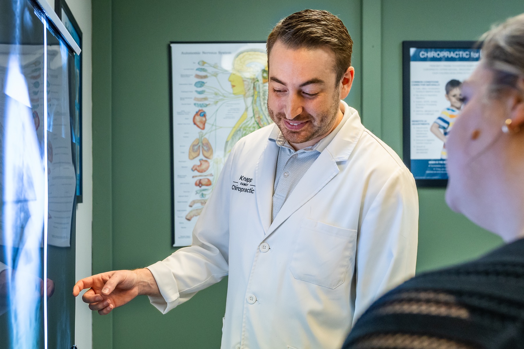 Dr. Connor Knapp reviewing a full-spine X-ray with a patient at Knapp Family Chiropractic